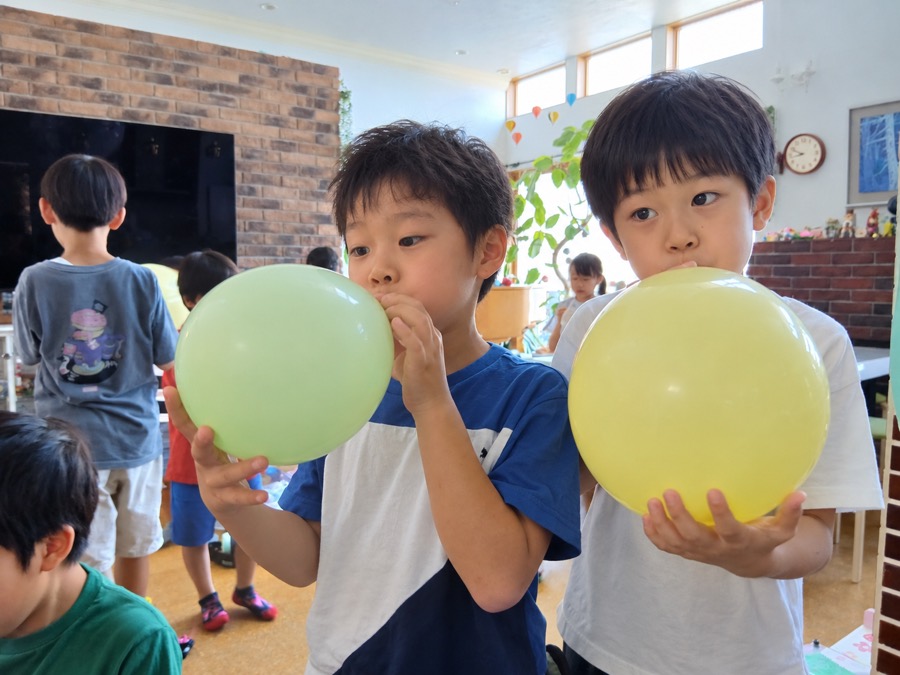 風船をふくらませる子どもたち