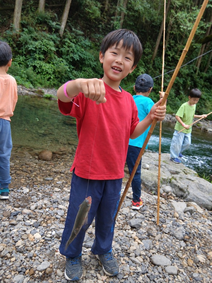川で釣った魚を見せてくれる子ども
